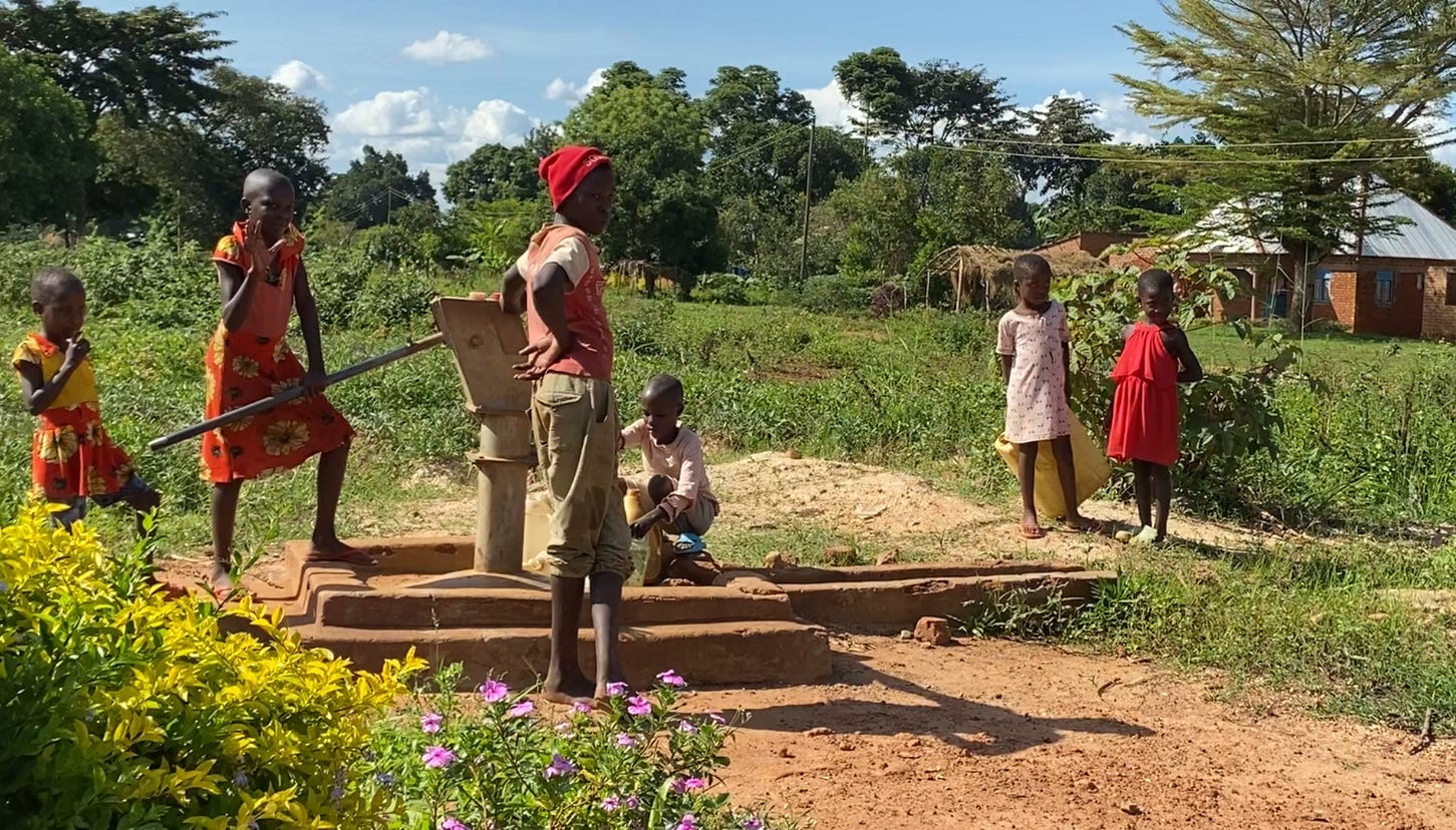 children around a well in Uganda